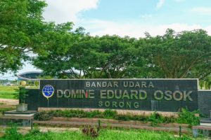 Sign of Domine Eduard Osok Airport Sorong and the airport building in the background