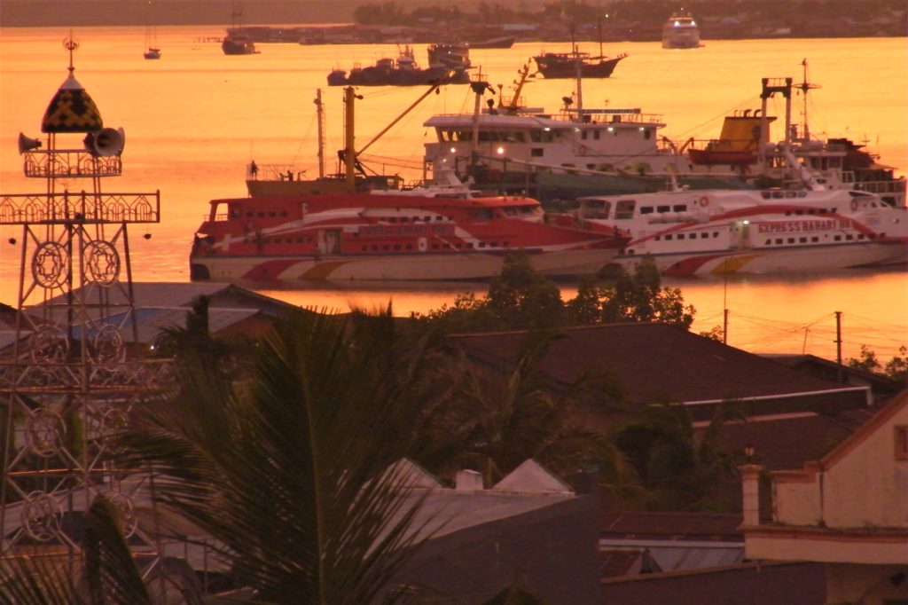 View of the harbour of Sorong during sunset with mosque, ferries and boats