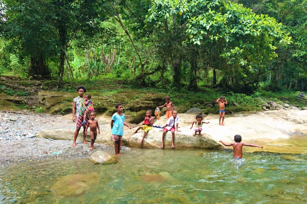 Playing kids on a river in an Papuan village